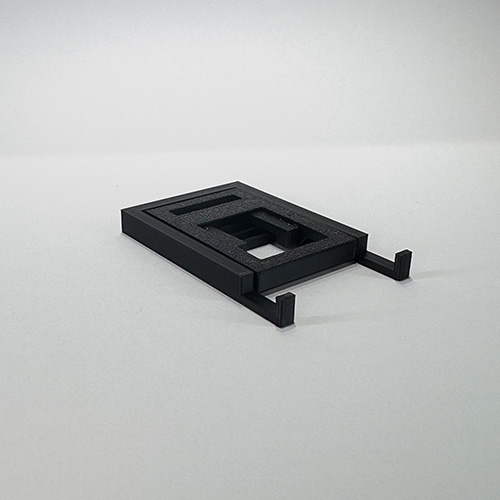kleiner portabler Handyständer in der Farbe schwarz in zusammengeklapptem Zustand (ca. 40mm x 75mm x 8mm)